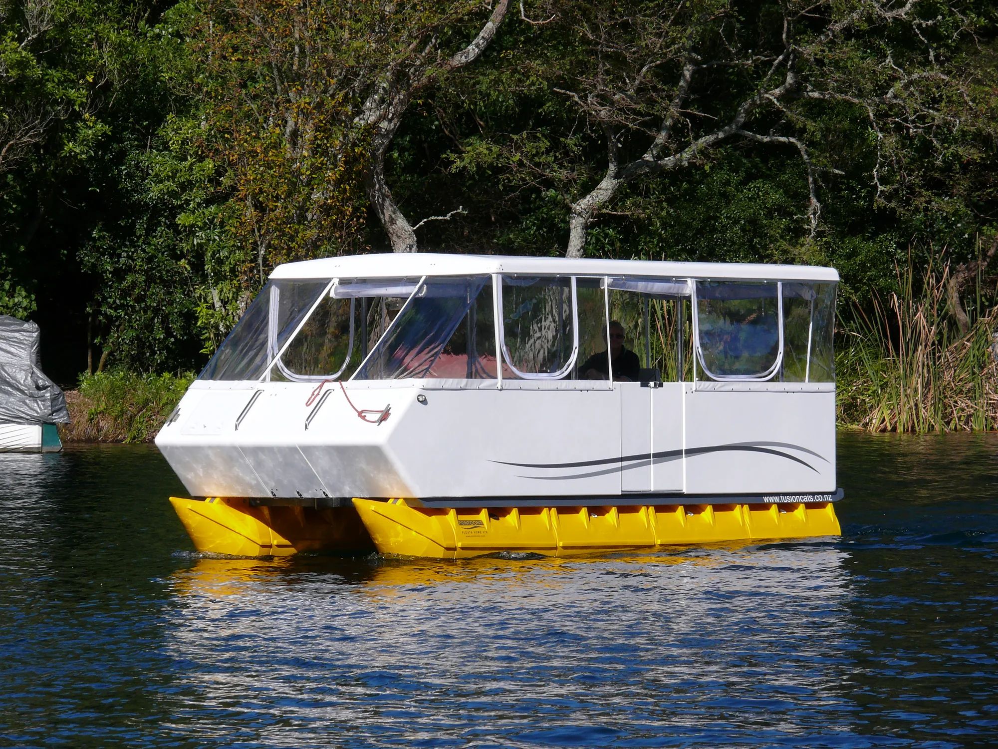 Fusion 570 pontoon boat with an enclosed white cabin on yellow pods