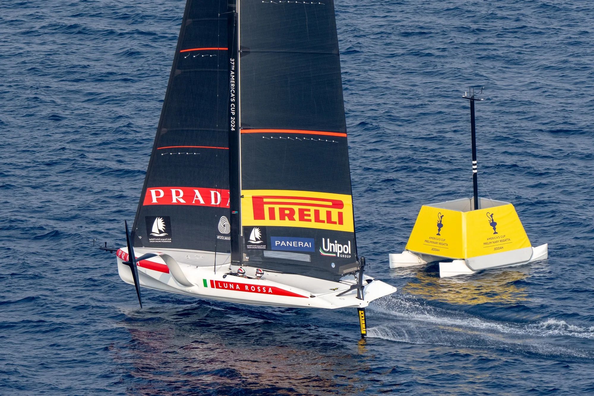 Luna Rossa America’s Cup yacht foiling past a yellow Pontoonz mark boat