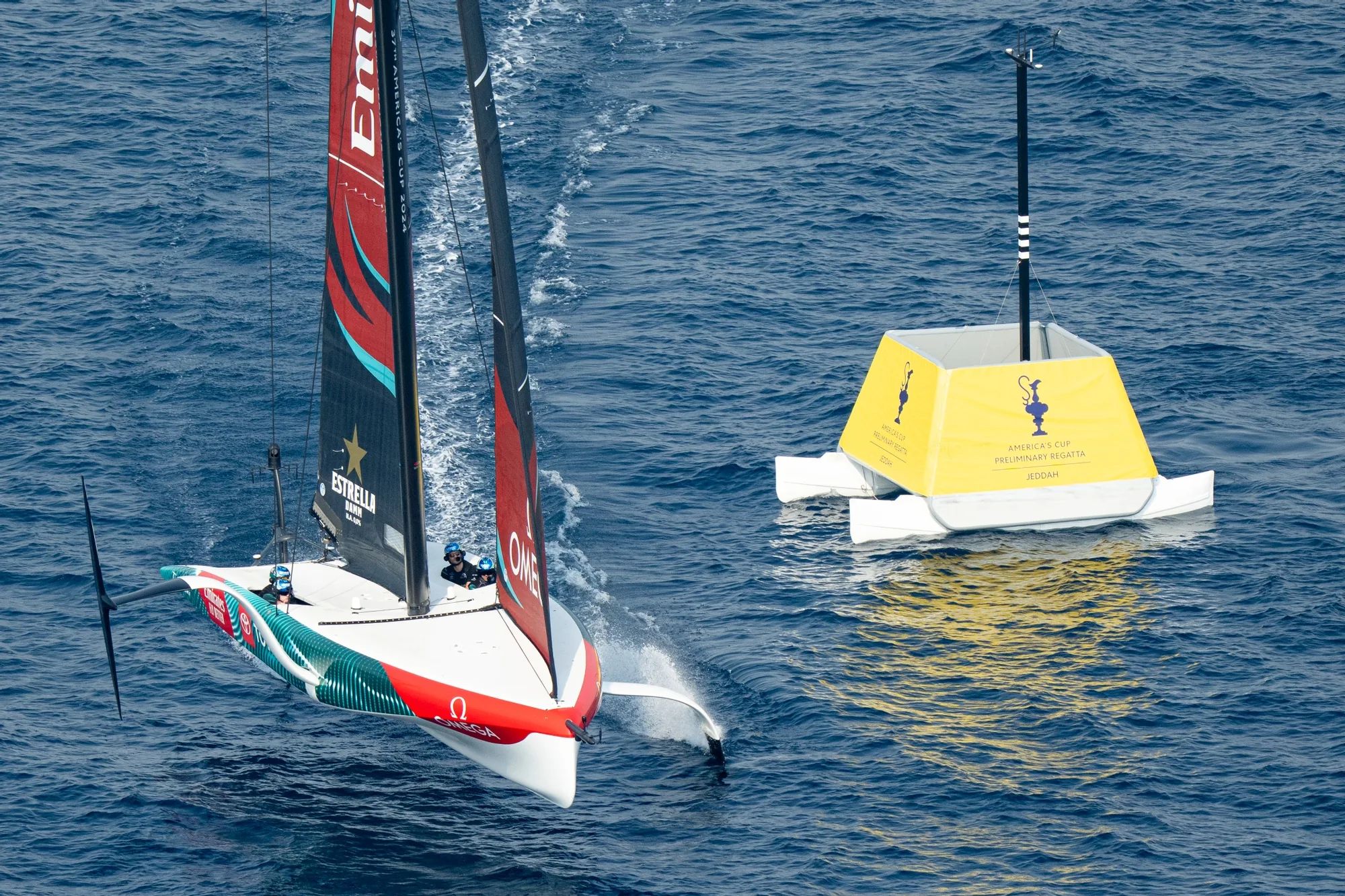 Emirates Team New Zealand foiling past a yellow Pontoonz mark boat