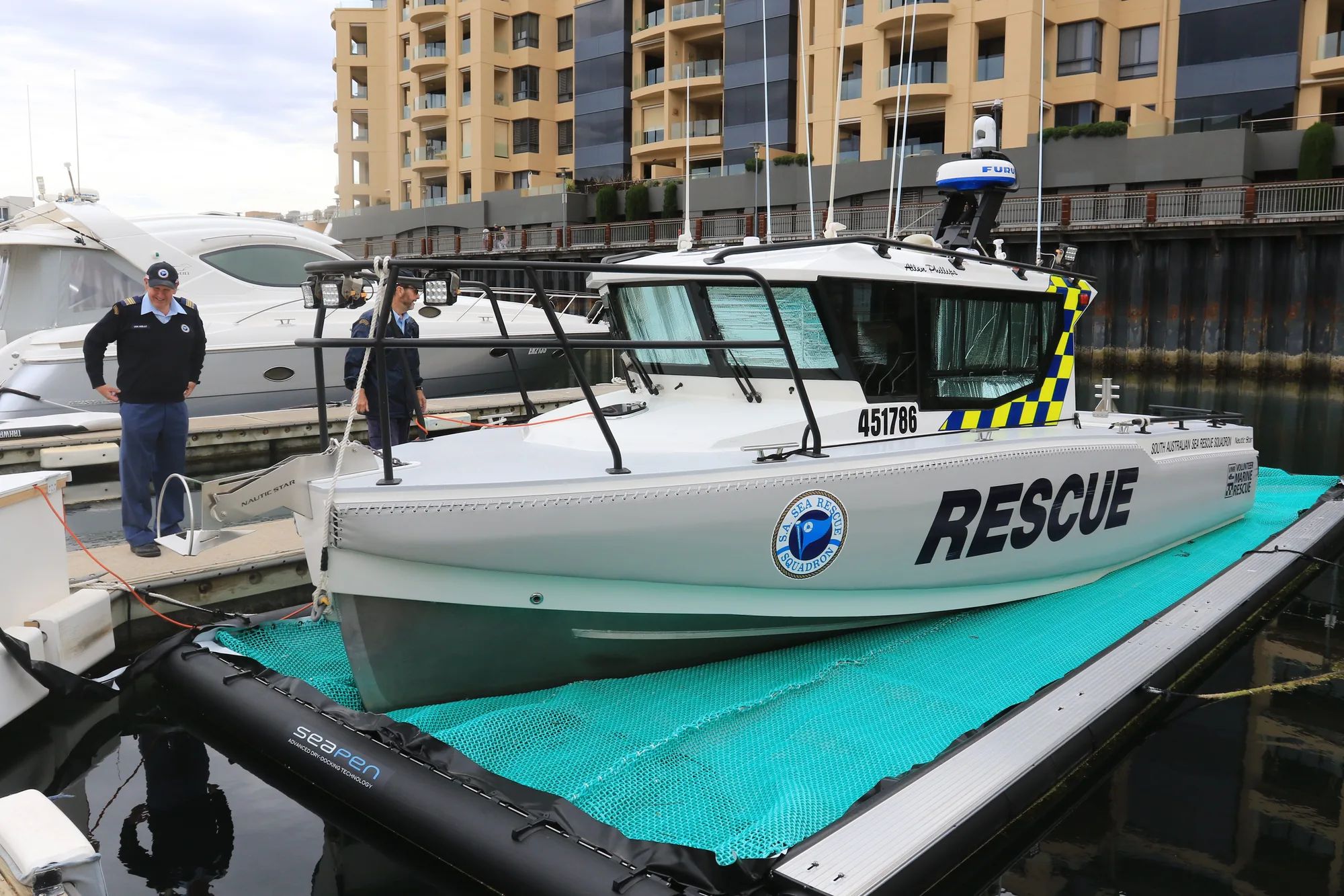 Sea rescue boat on a drive-on dock at a marina, crew standing by