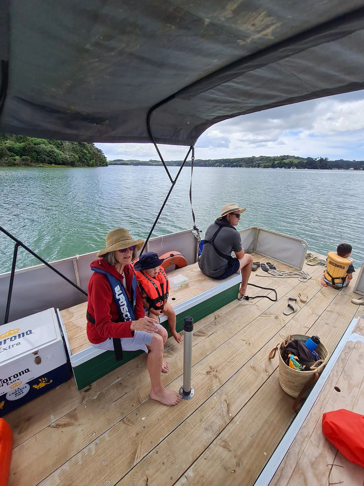 Family relaxing on the deck of a pontoon boat under a canopy