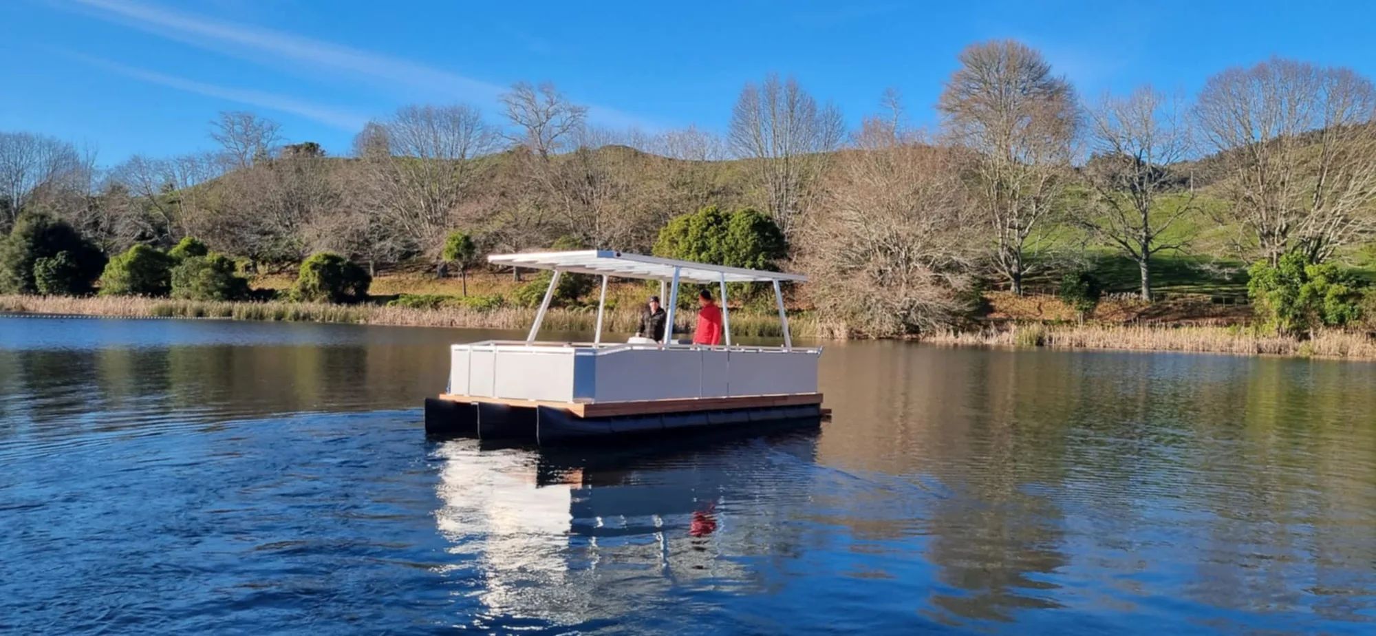 White pontoon boat with a shade roof on a calm river