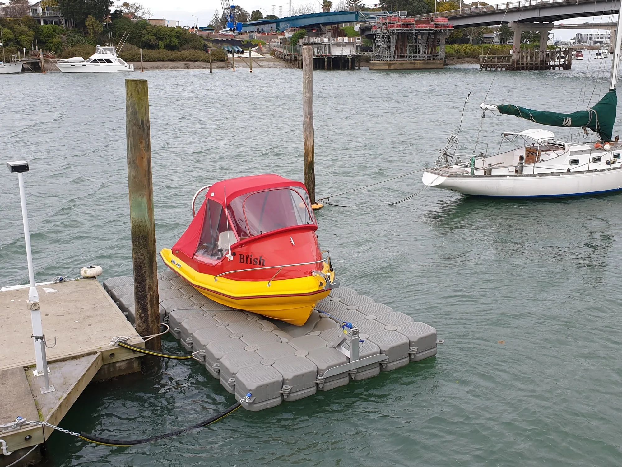 Small boat on a modular jet dock beside piles at Herald Island