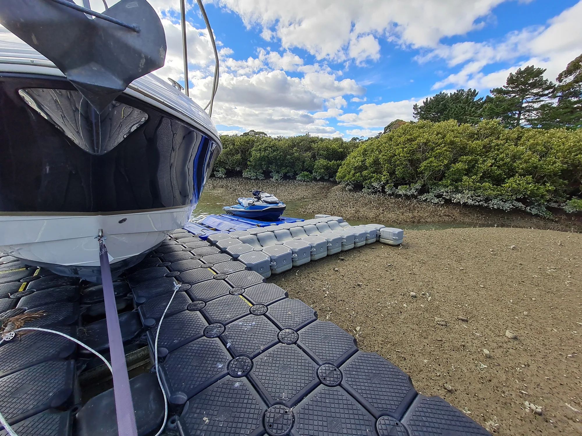Boat and jet ski on a modular floating dock at Karaka