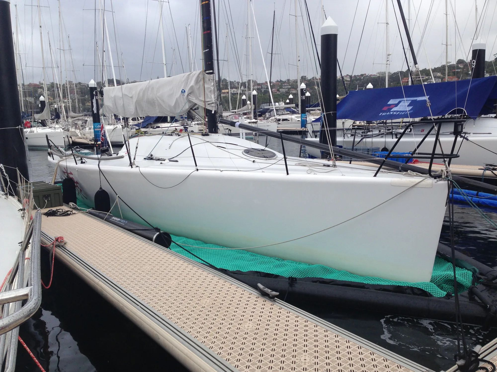 Yacht stored out of the water on a floating drive-on dock in a marina