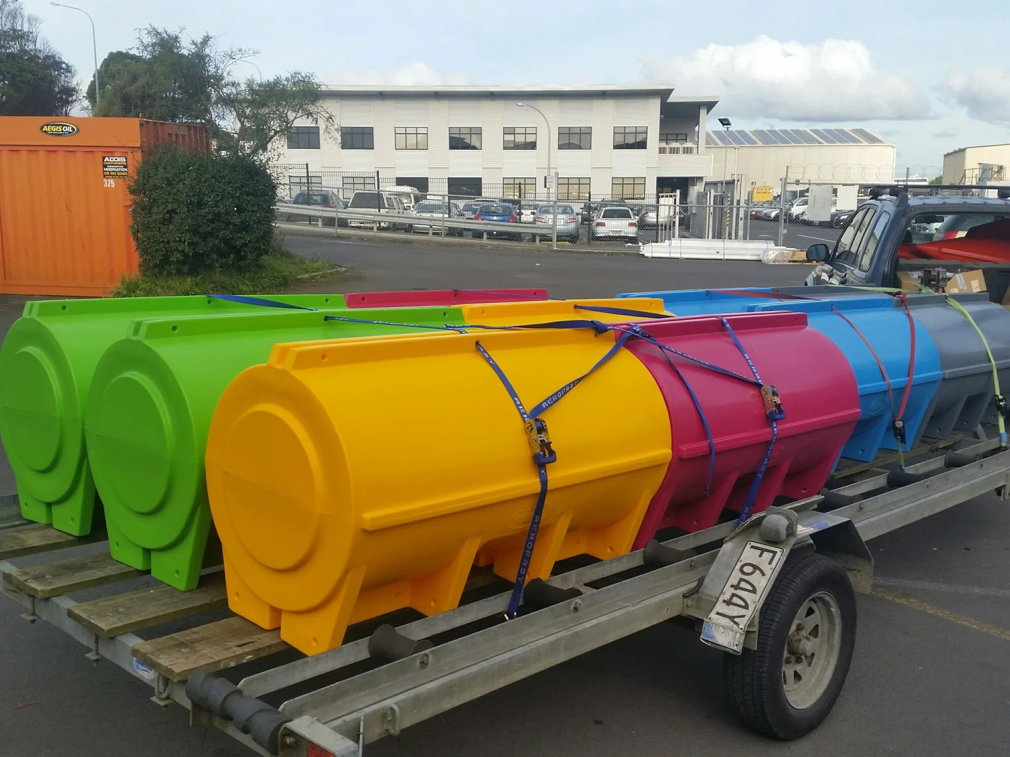 Green, yellow, pink and blue pods strapped onto a trailer