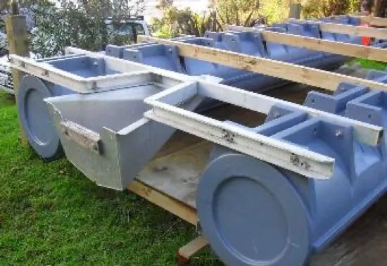 Metal frame on blue-grey pods on a lawn, before decking