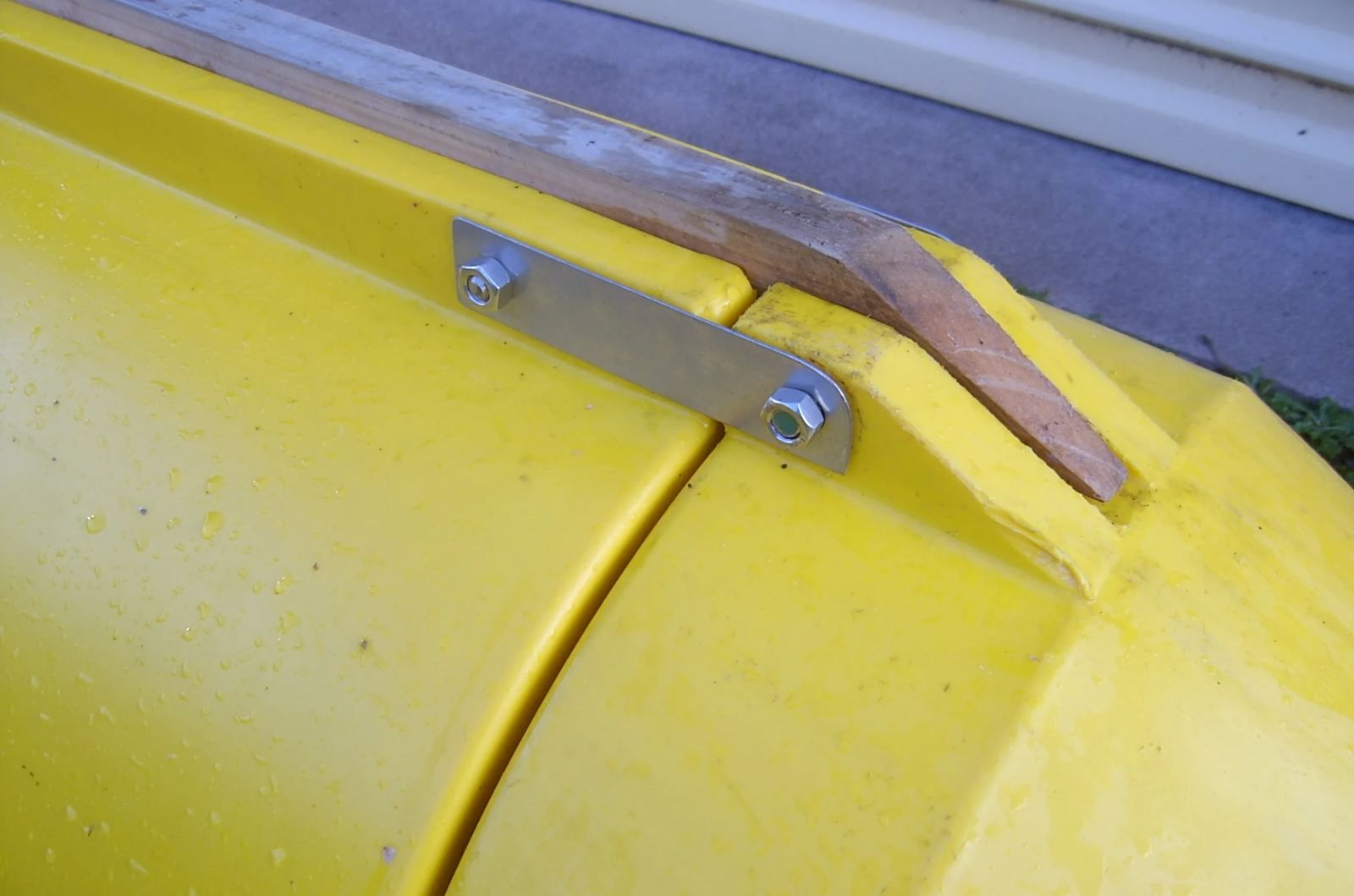 Close-up of a stainless bracket bolted through a yellow pod tie-off point