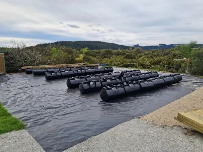 Rows of black pods laid out on a membrane before decking