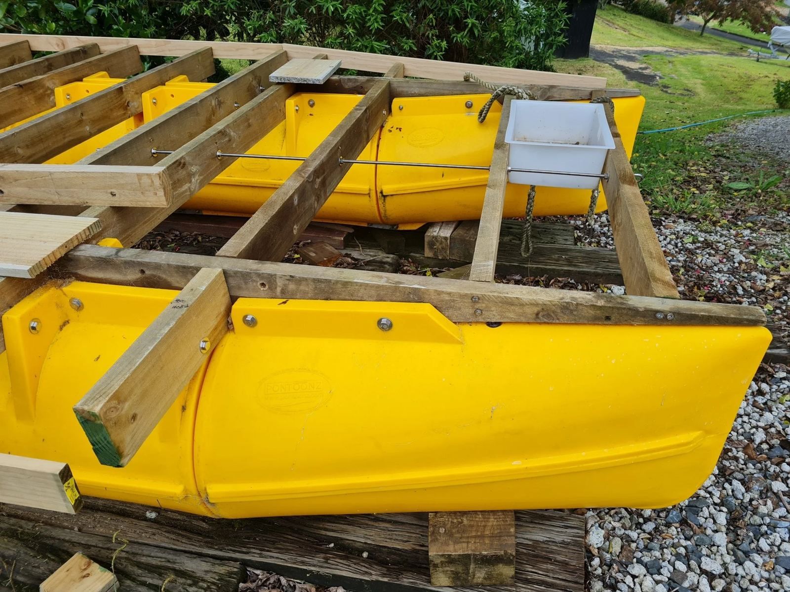 Yellow Main Boat Pods bolted to timber runners during a build