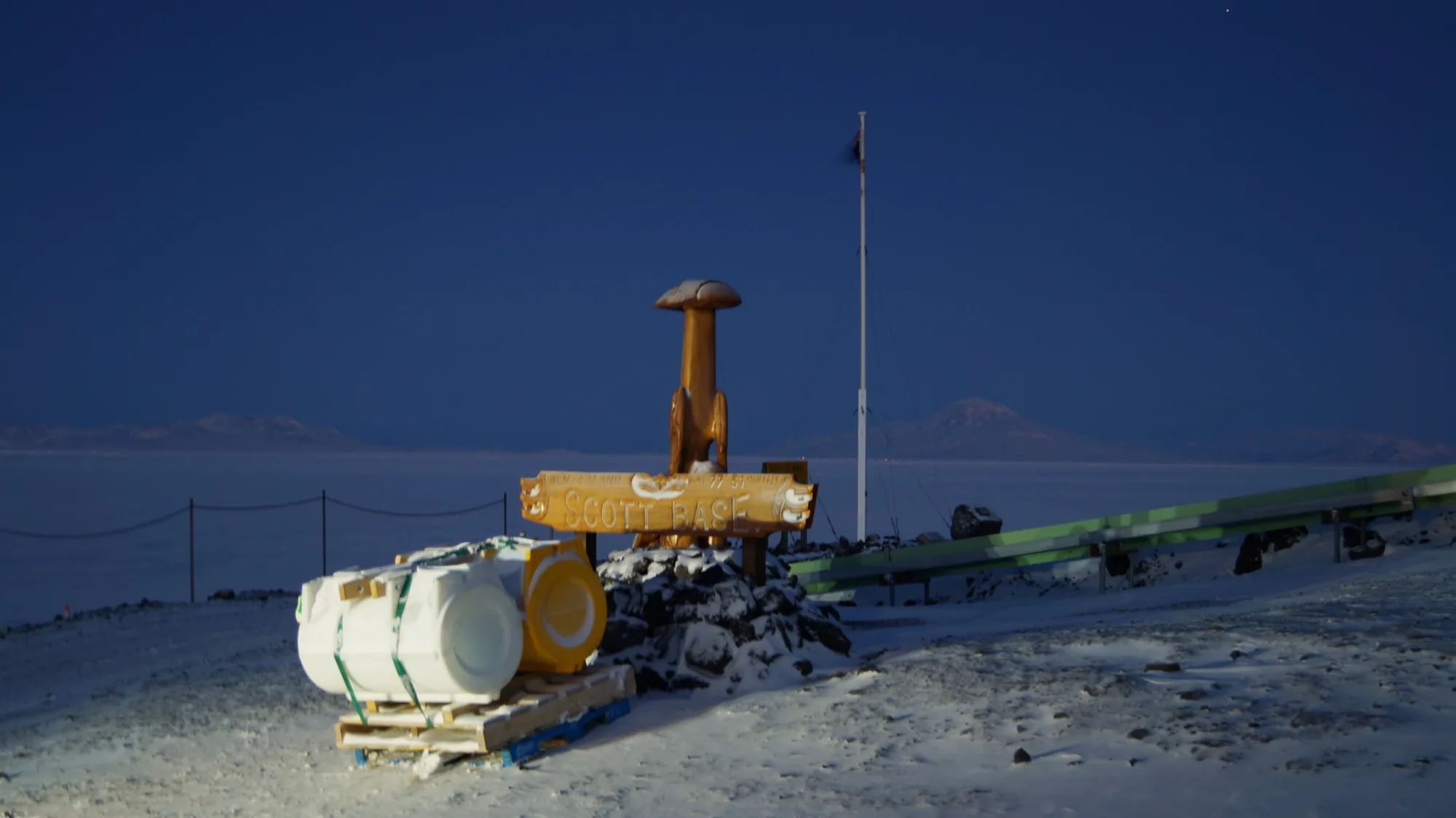 Two pods on a pallet beside the Scott Base sign in Antarctica