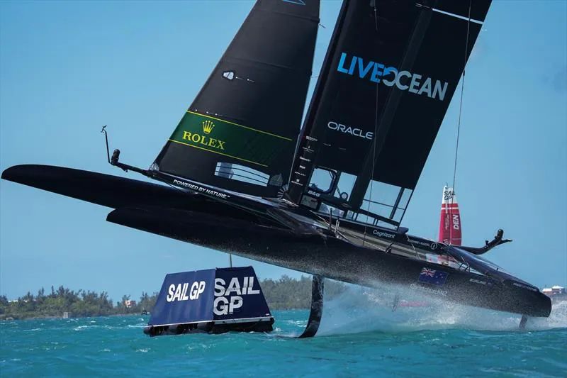 New Zealand SailGP F50 foiling past a SailGP-branded marker boat