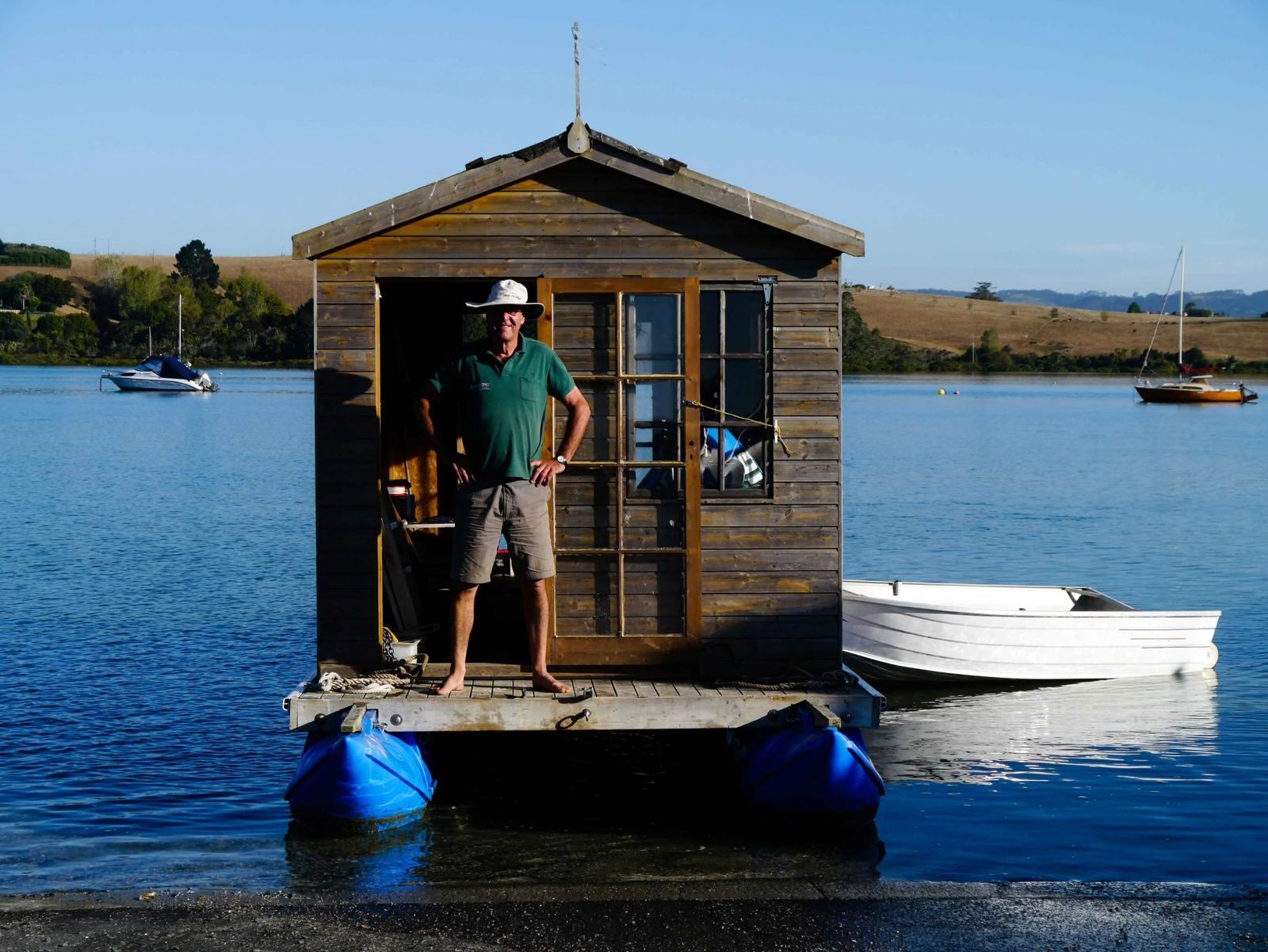 The original Pontoonz shed houseboat with its owner in the doorway