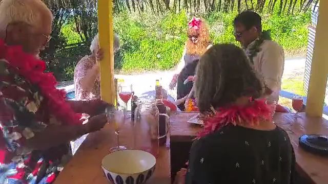 Video: guests in leis at a tiki bar under a thatched roof